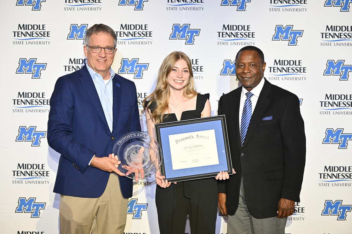 Middle Tennessee State University senior forensic science major Sydney Robbins, center, of Memphis, Tenn., receives the 2023-24 Provost’s Award April 22 from Provost Mark Byrnes, left, as MTSU President Sidney A. McPhee observes during the Student Government Association and Center for Student Involvement and Leadership Awards Banquet in the Student Union Ballroom on the MTSU campus in Murfreesboro, Tenn. The award is annually given to a student who best demonstrates outstanding academic achievement. (MTSU photo by James Cessna)