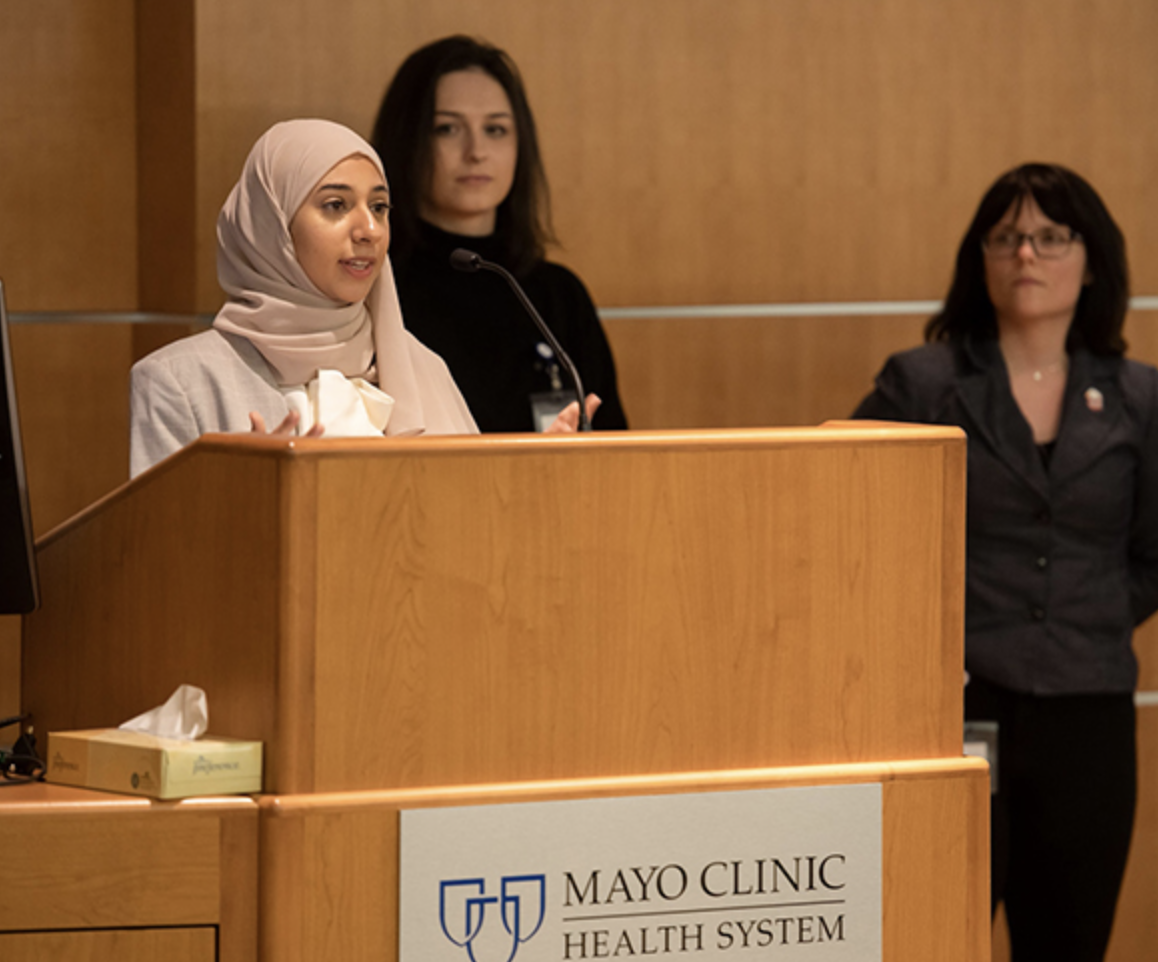 Janna Abou-Rahma speaking at podium during pre-conference Mayo Clinic Social Determinants of Health Challenge